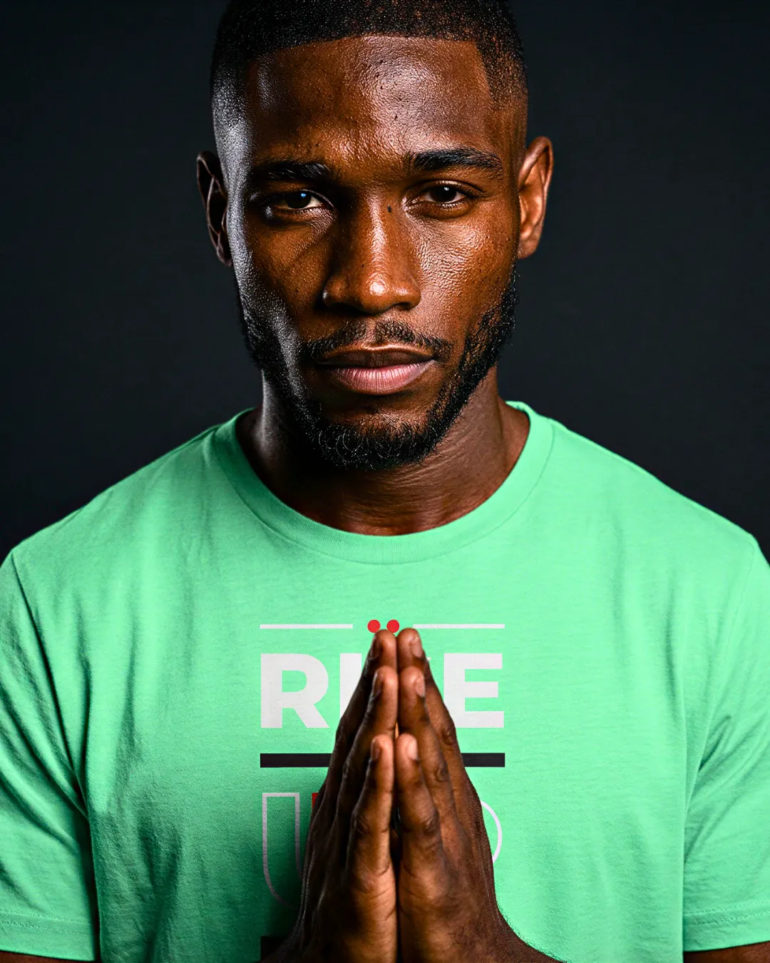 Man Praying in Green Tee